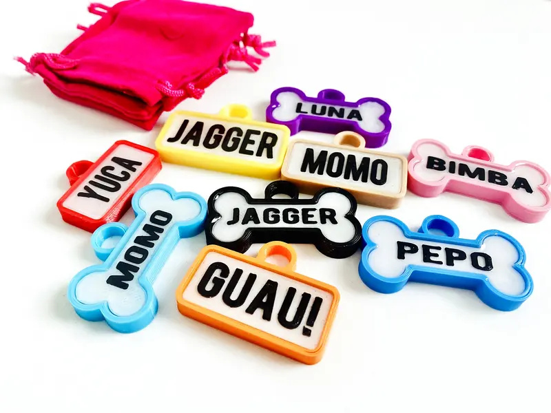 Chapitas de perro de colores con su bolsita: Guau, Jagger, Momo, Luna, Yuca y Pepo