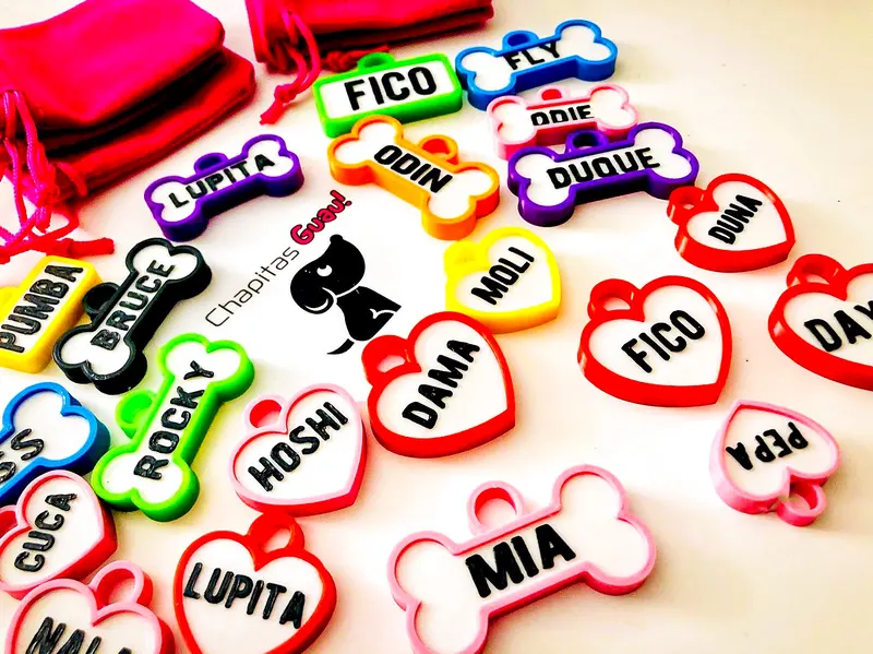 Chapitas de perro de corazones y huesos con la tarjeta de Chapitas Guau: Fico, Mia, Lupita, Dama y Hoshi